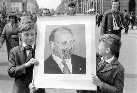 In a parade, two boys hold image of communist leader